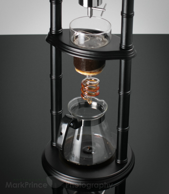 Iced coffee dripping through an iced coffee brewing tower device.