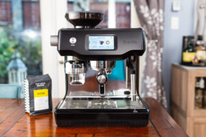 Breville Oracle Touch espresso machine in black on a table.