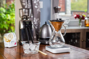 Japanese Iced Coffee setup with a chemex and a kone filter, and a grinder in the background
