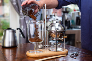 Using a modern style balance brewer, adding coffee to the brewing side of the device.