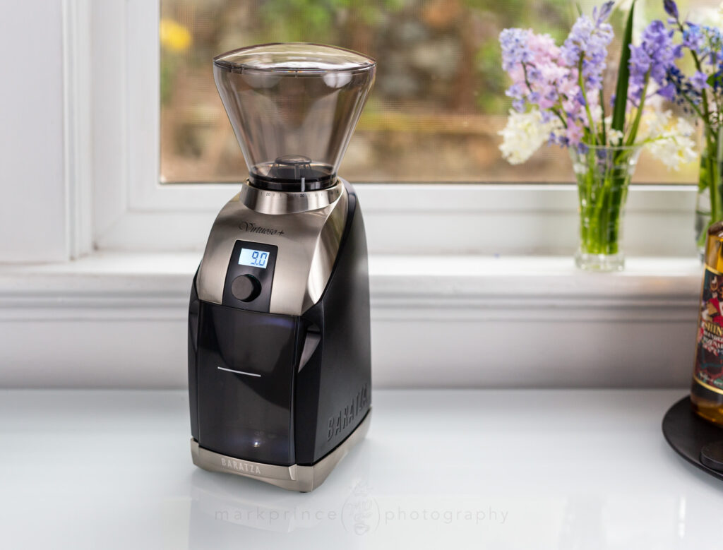 Baratza Virtuoso+ Grinder on a counter by a window.