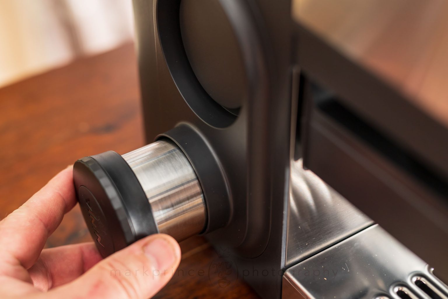 A slot on the left side of the machine is the home for the tamper when not being used.